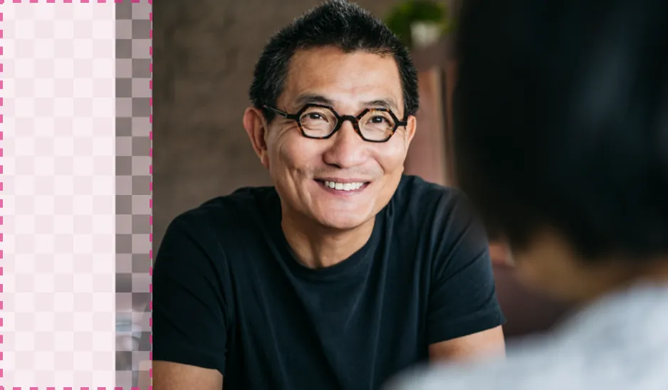 A man wearing glasses smiles as he converses. A dashed line indicates where we would like to extend the background.