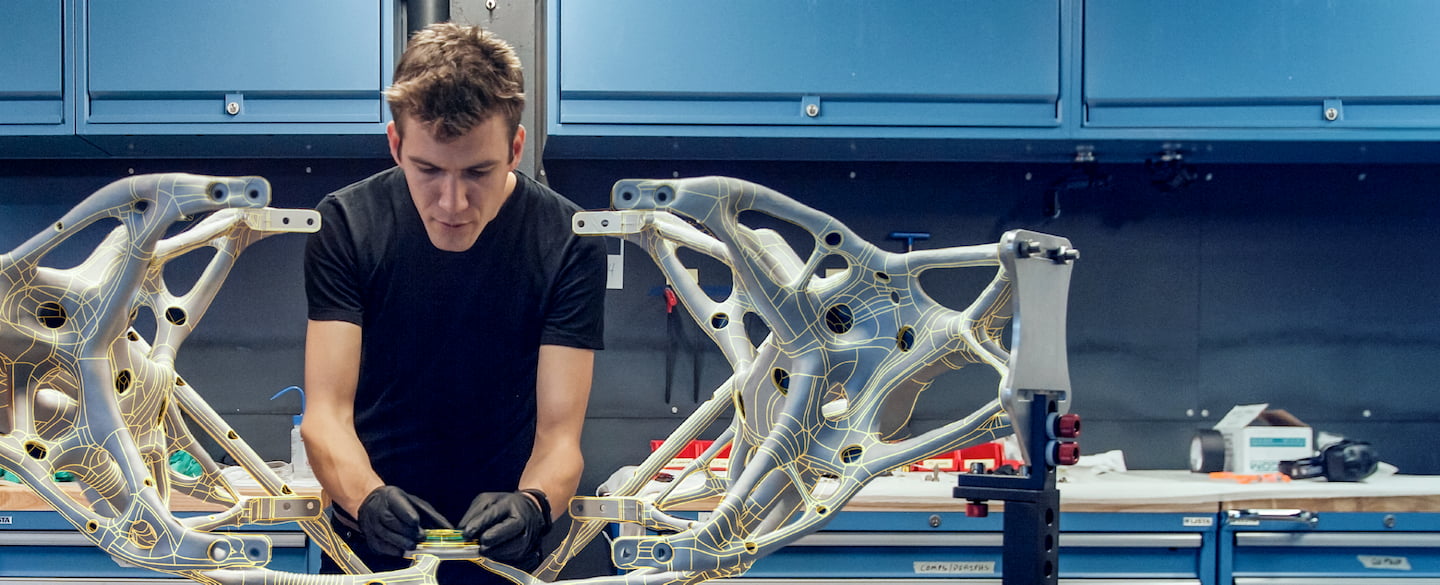 Person working in shop with large cast-metal parts.