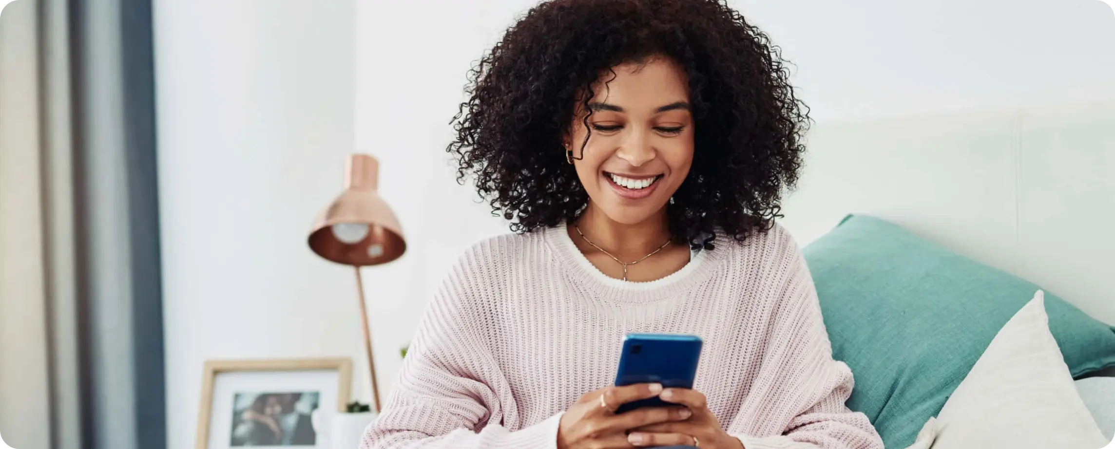 Person in living room, smiling at their phone